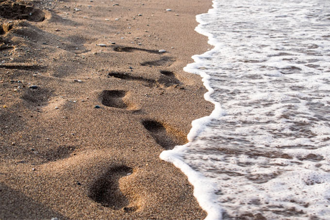 Strand: Fußspuren im Sand am Meer